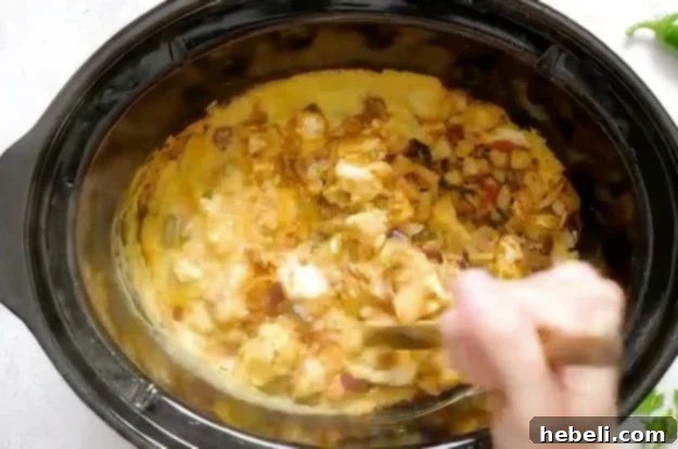 Stirring the queso ingredients halfway through cooking in slow cooker