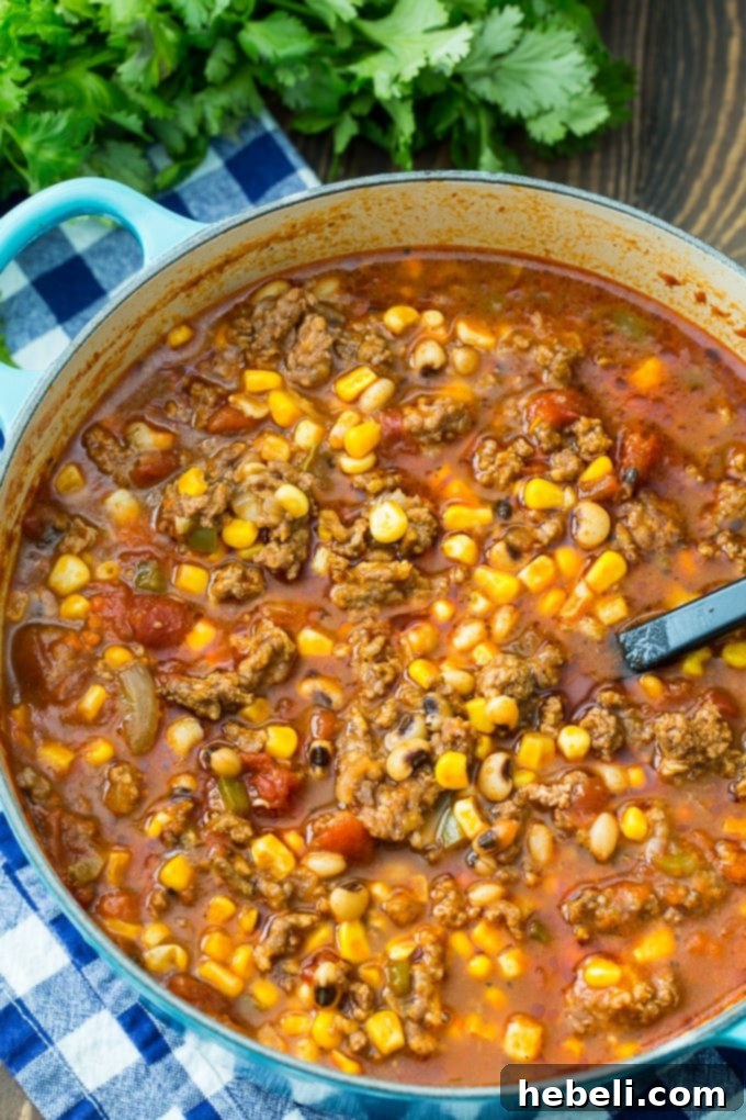 Close-up of Black-Eyed Pea and Sausage Chili bubbling in a large Dutch oven.