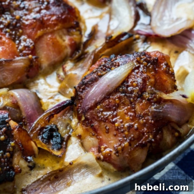 Crispy Bacon Wrapped Chicken Thighs with Creamy Mustard Sauce served in a cast iron skillet