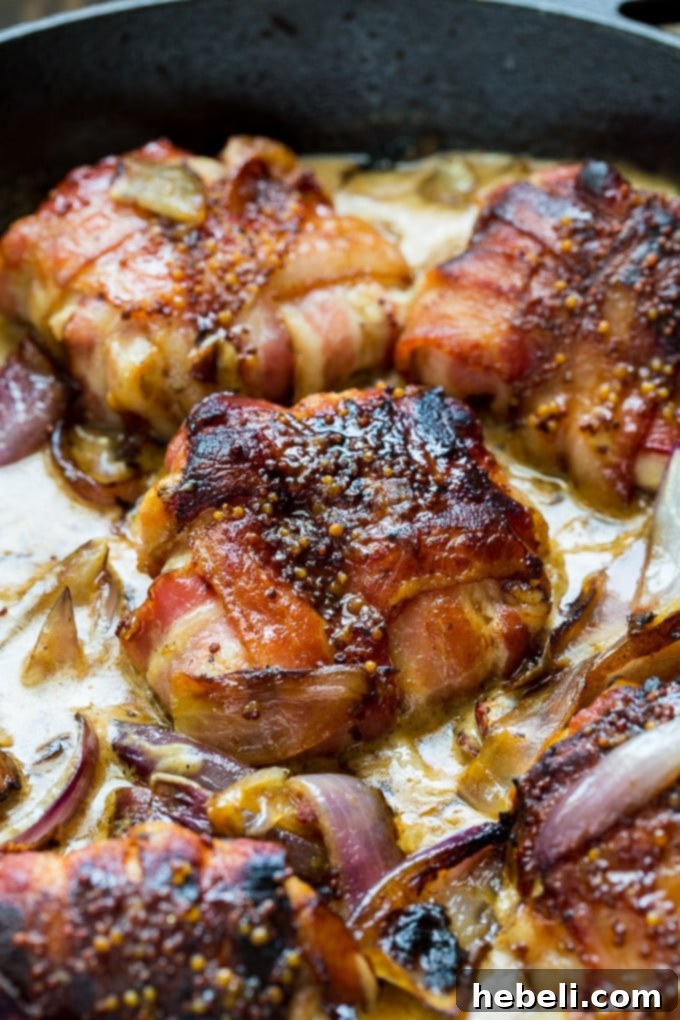 Plated Bacon Wrapped Chicken Thighs with Mustard Cream Sauce, garnished and ready to be served