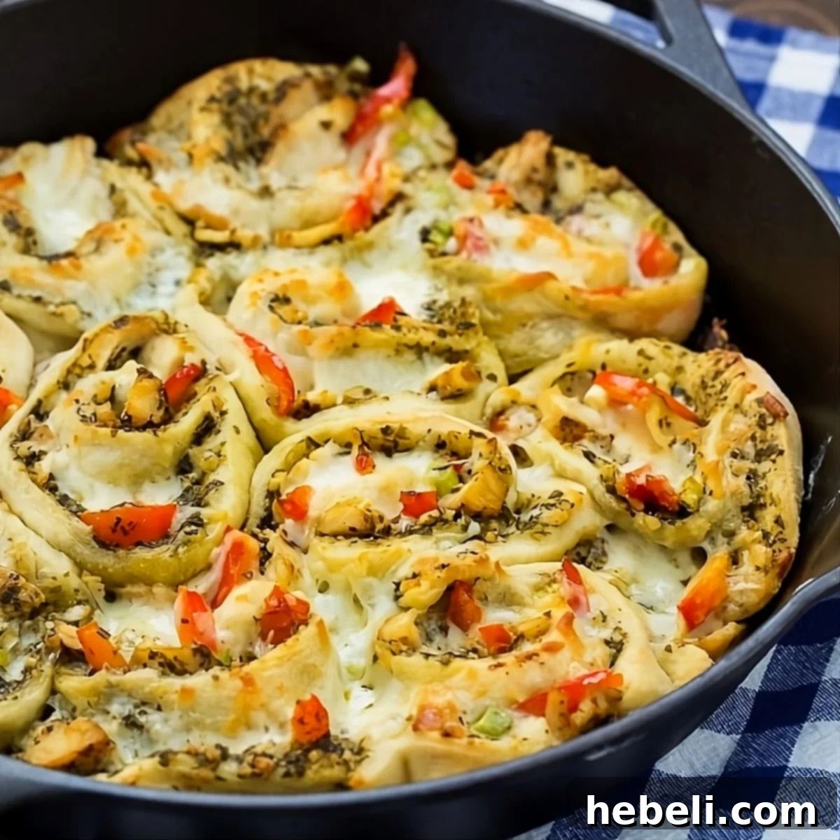 Golden brown Chicken Pesto Pizza Rolls presented beautifully in a cast iron pan, ready to serve.