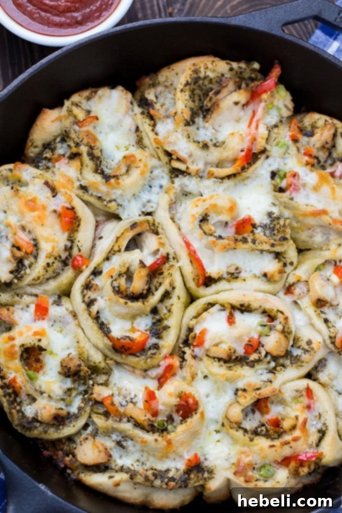 Easy Chicken Pesto Pizza Rolls cooling on a wire rack after baking, showing golden crust.