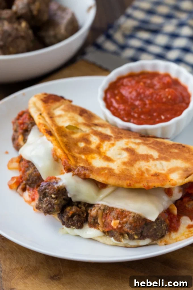 Close-up of a Meatball and Mozzarella Panini, showing melted cheese and rich sauce