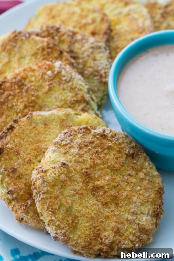 Low fat and crispy Air Fried Green Tomatoes arranged on a plate with dipping sauce.