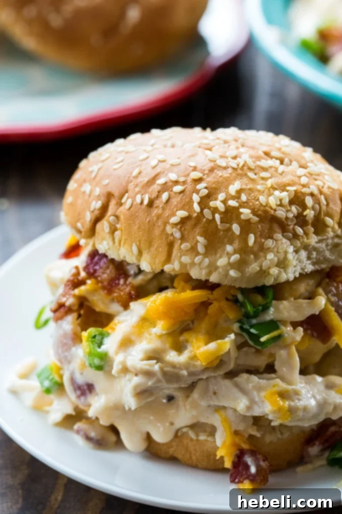 Addictive Instant Pot Chicken 10 A delicious Instant Pot Crack Chicken sandwich, showcasing the creamy filling on a toasted bun with fresh green onions.