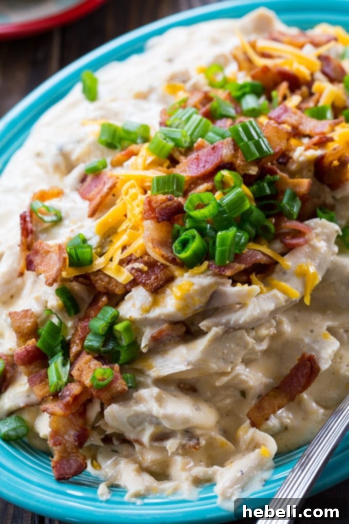 Addictive Instant Pot Chicken 3 Close-up of Instant Pot Crack Chicken in the pot, richly coated in its creamy sauce and topped with crumbled bacon and melted cheese.