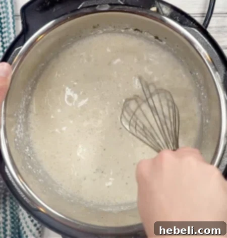 Addictive Instant Pot Chicken 6 Whisking the creamy sauce in the Instant Pot on 'Sauté' mode until smooth and well combined.