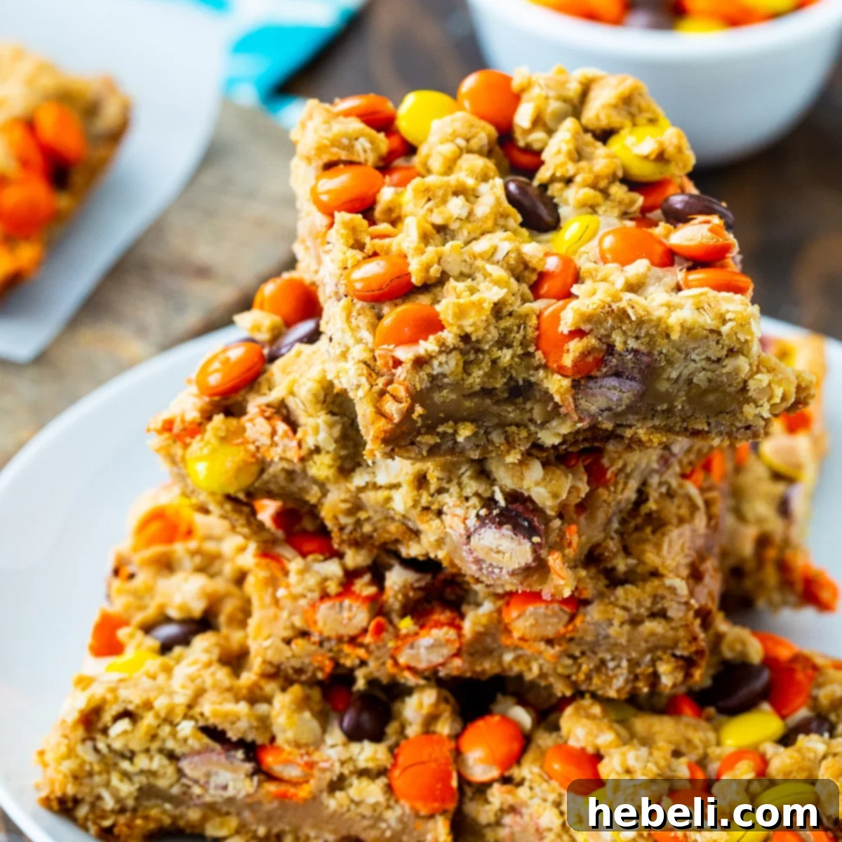 Stacked Reese's Pieces Oatmeal Bars showcasing the rich peanut butter middle and colorful candy topping.