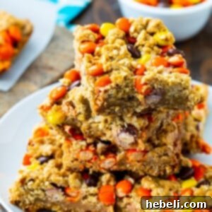 Reese's Pieces Oatmeal Bars stacked neatly on a plate, ready to be served.