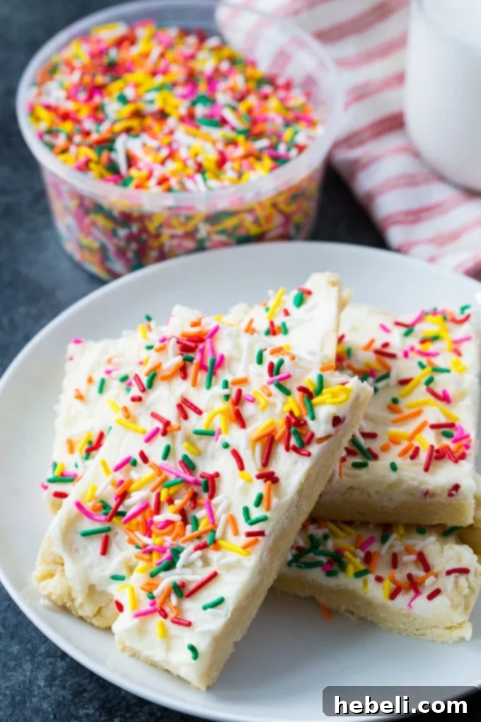 A close-up of Sugar Cookie Bars with a thick layer of white buttercream frosting
