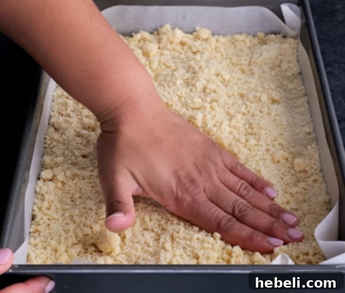 Pressing the sugar cookie dough evenly into the baking pan