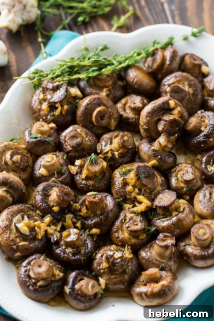 Golden Garlic Butter Roasted Mushrooms 4 A serving bowl filled with irresistible Garlic Butter Roasted Mushrooms, garnished with fresh herbs.