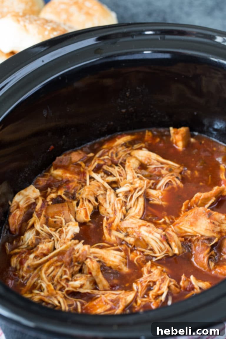 Smoky Slow Cooker Pulled Chicken 3 Crock Pot Chipotle Chicken is an easy dump and go slow cooker recipe, shown in a bowl with sauce.