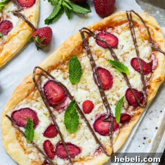 Delicious Strawberry Nutella Dessert Pizza with fresh mint leaves on a white plate