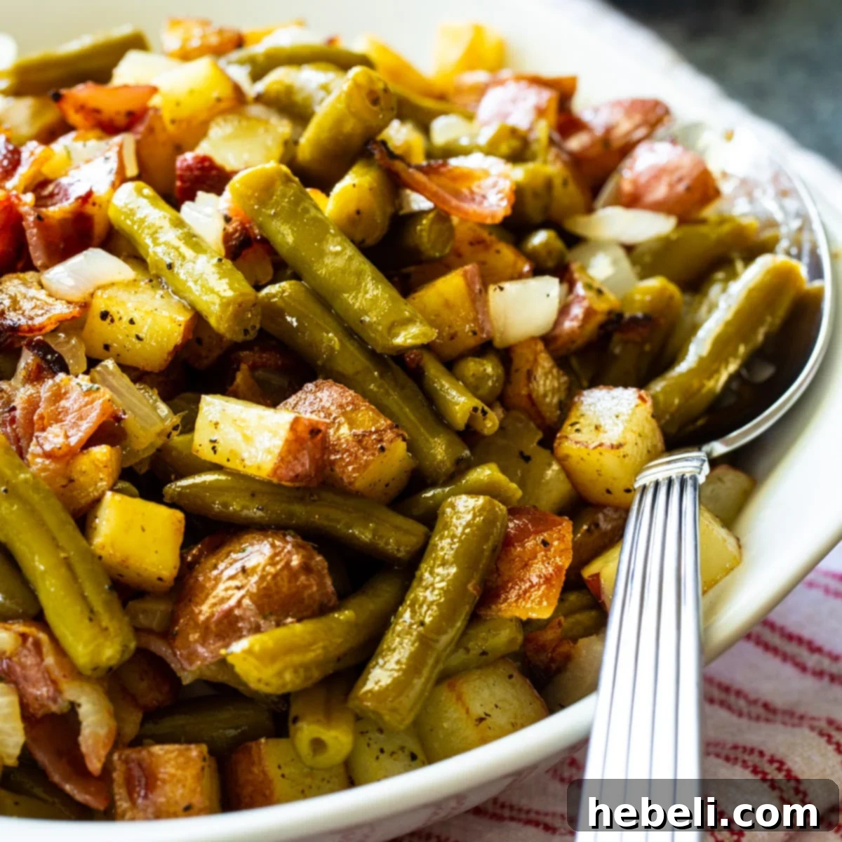 A serving bowl filled with Country Ranch Green Beans and Potatoes, garnished with fresh herbs and crumbled bacon, ready to be enjoyed.