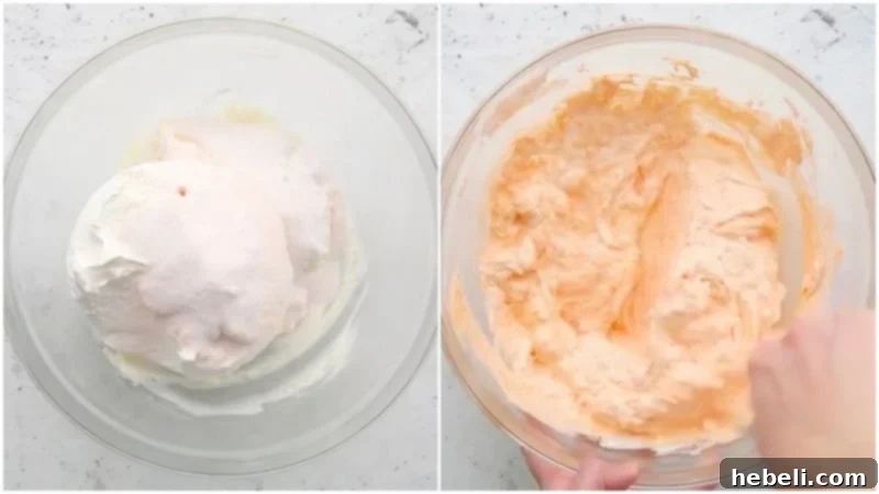 Golden Peach Ambrosia 5 Cool Whip and dry peach gelatin mix being gently stirred into the creamy base in a large bowl.