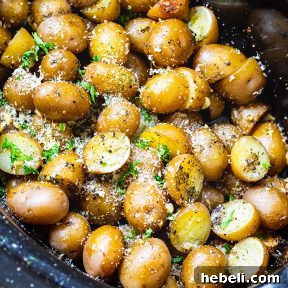 Garlic Parmesan Potatoes cooking in a slow cooker, looking tender and seasoned.