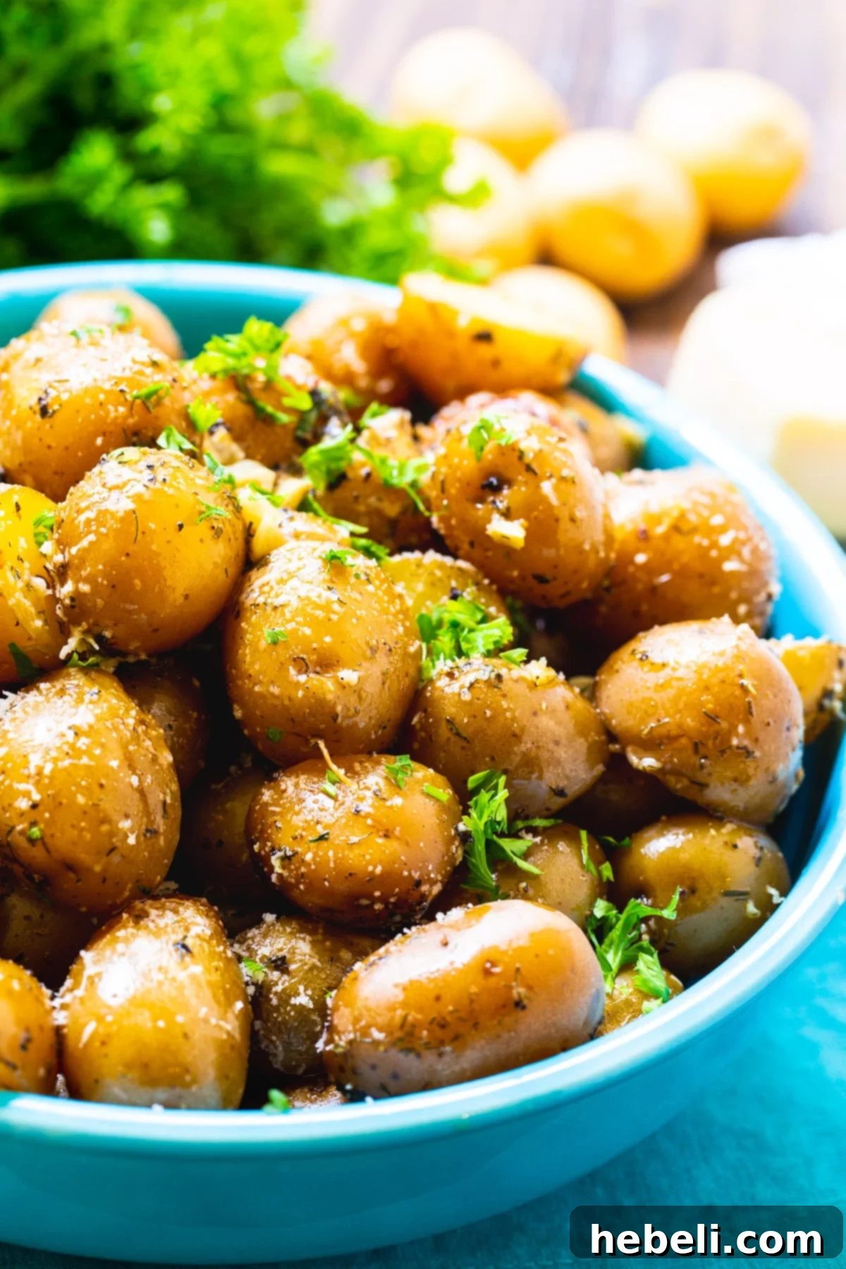 Close-up of Slow Cooker Garlic Parmesan Potatoes in a blue serving bowl.