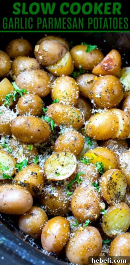 Close-up of Slow Cooker Garlic Parmesan Potatoes in crock pot, topped with fresh herbs.