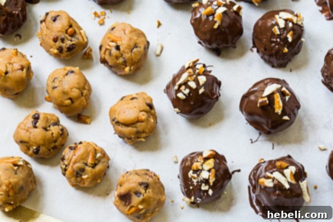 A baking sheet displaying both uncoated and chocolate-covered Peanut Butter Pretzel Truffles, ready for chilling and setting.
