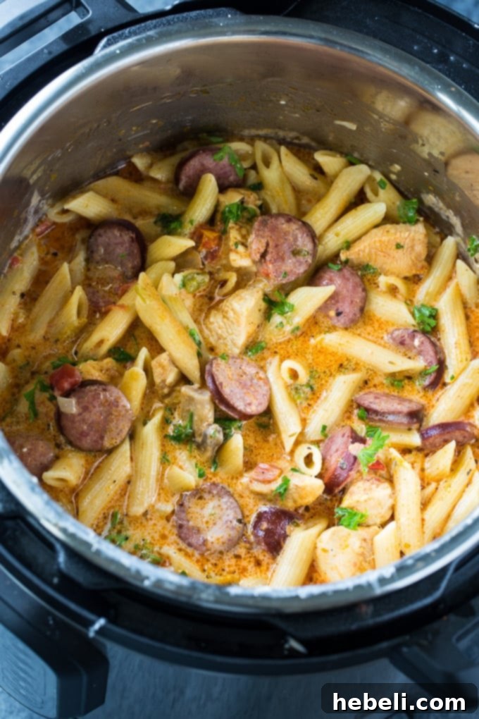 Velvety Cajun Instant Pot Pasta 3 Instant Pot Creamy Cajun Pasta served in a white bowl, garnished with a sprinkle of fresh green parsley, highlighting the vibrant colors and creamy texture.