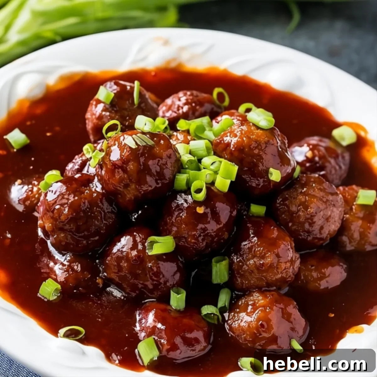 Delicious Instant Pot Sweet and Spicy Meatballs served in a bowl, garnished with fresh green onions.