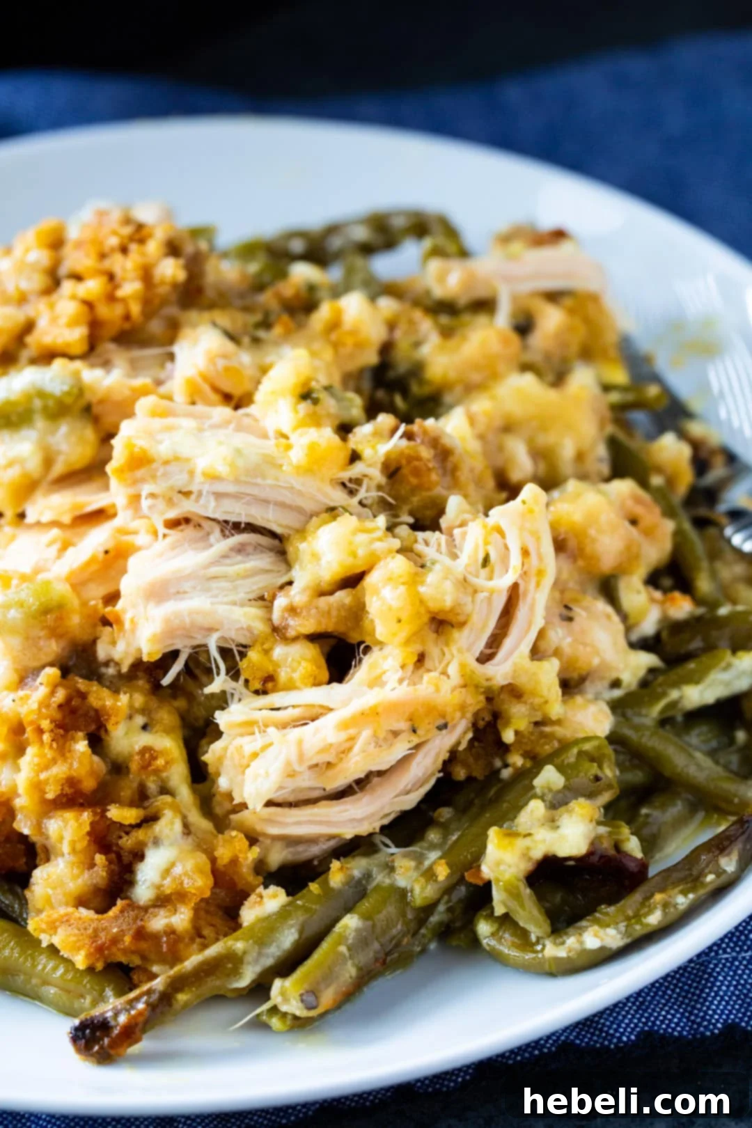 A close-up shot of the finished Crock Pot Chicken and Stuffing with Green Beans, dished up on a plate, showing the fluffy stuffing, tender chicken, and vibrant green beans.