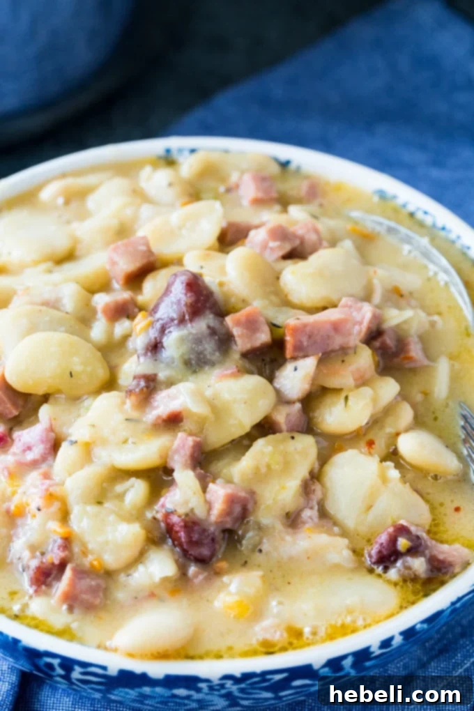 A delicious serving of creamy butter beans with smoked ham, presented as a hearty meal. Ideal for a comforting dinner or gathering.