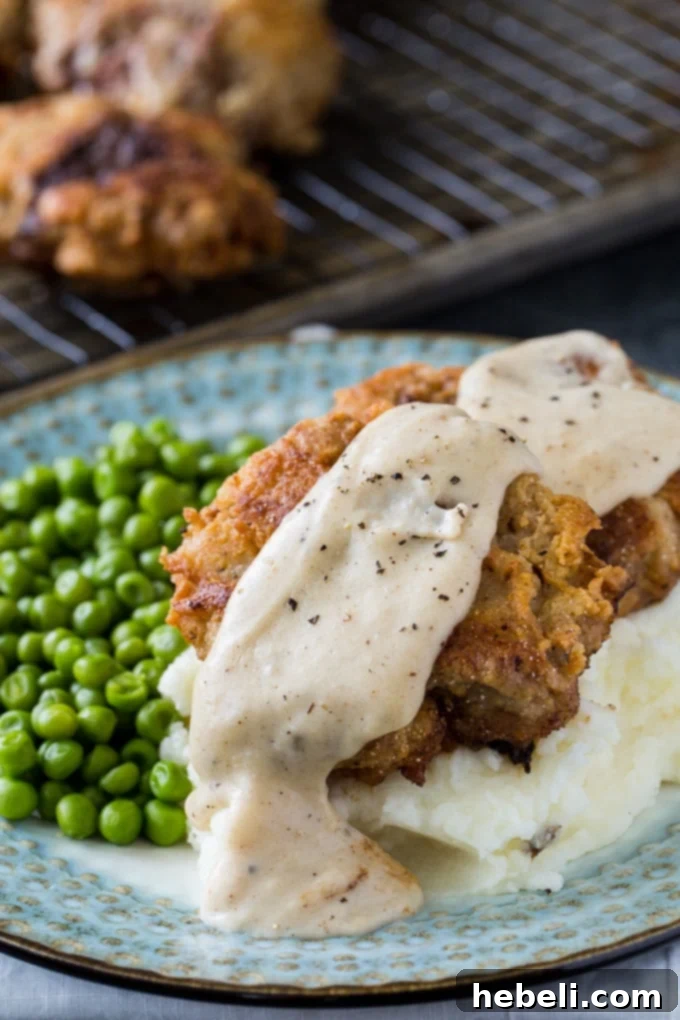 Chicken Fried Hamburger with White Gravy served on a plate.