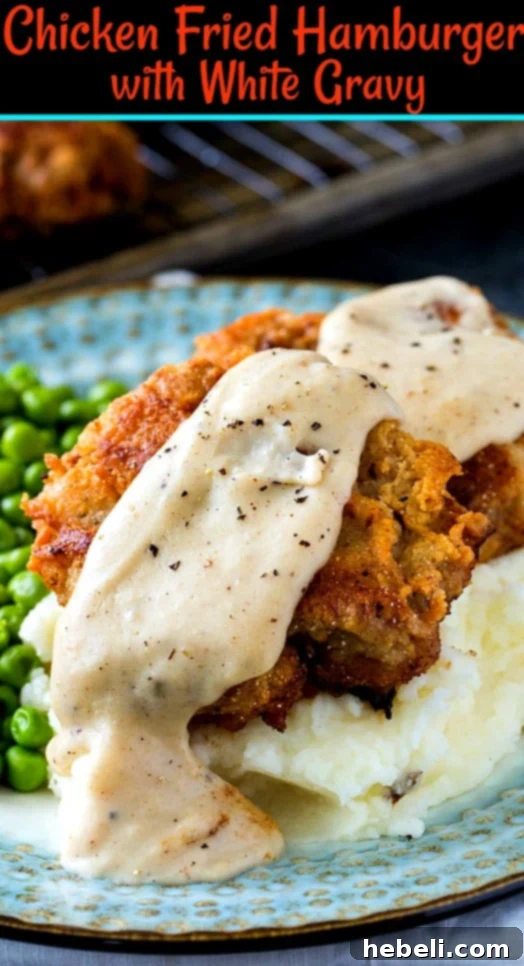 Two Chicken Fried Hamburger patties covered in white gravy, served over mashed potatoes.