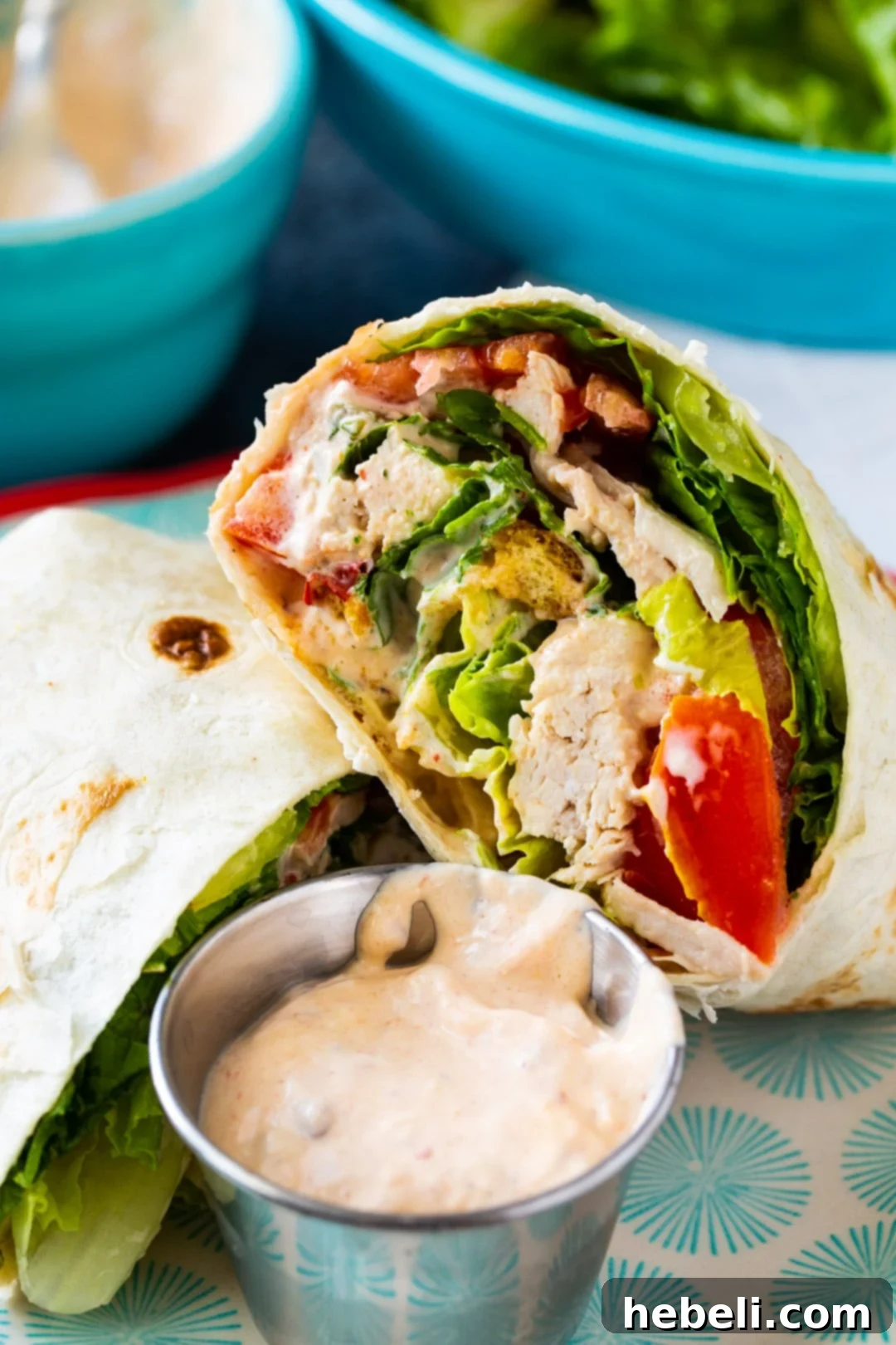 A whole Spicy Chicken Caesar Salad Wrap artfully placed on a plate, ready to be enjoyed.