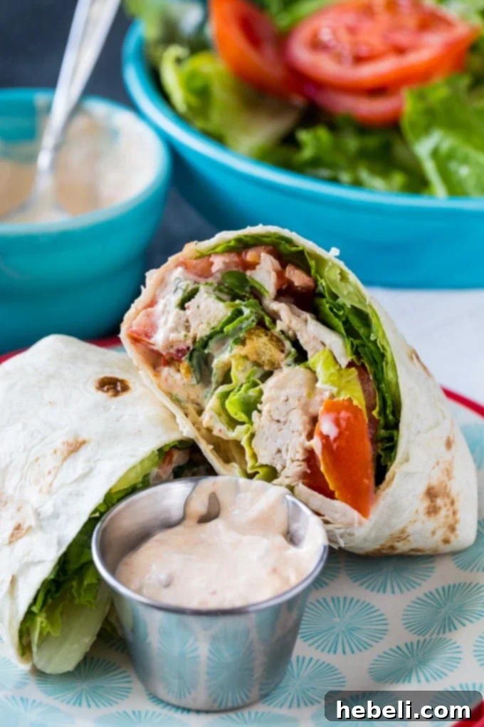 Close-up of a Spicy Chicken Caesar Salad Wrap, showing the rich texture of chicken, lettuce, and dressing.