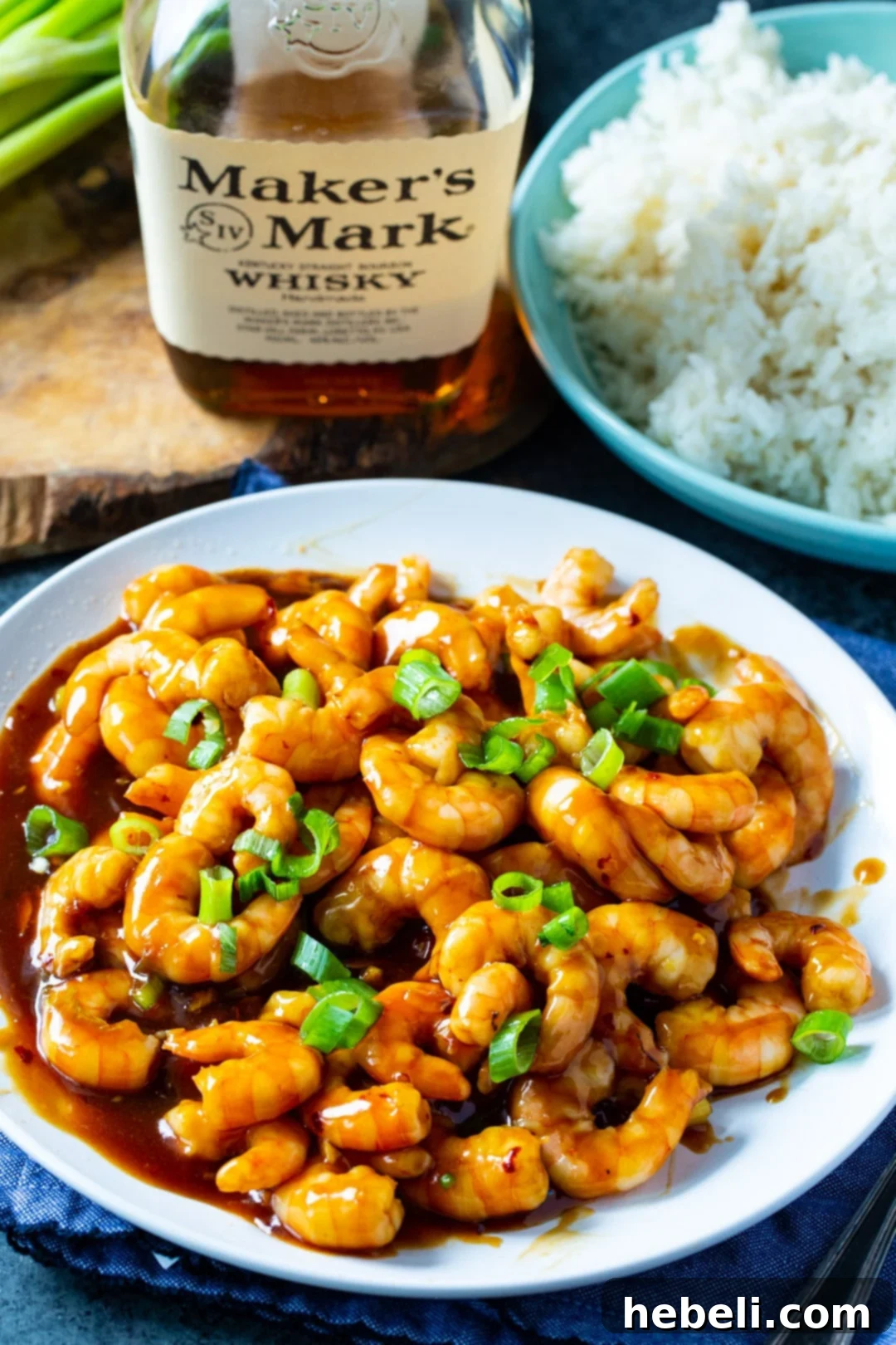 Bourbon Glazed Shrimp 4 Bourbon Shrimp on a plate with a bottle of bourbon in the background.