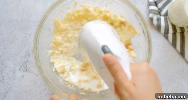 Beating butter and sugar until light and fluffy in a mixing bowl for the cake batter.