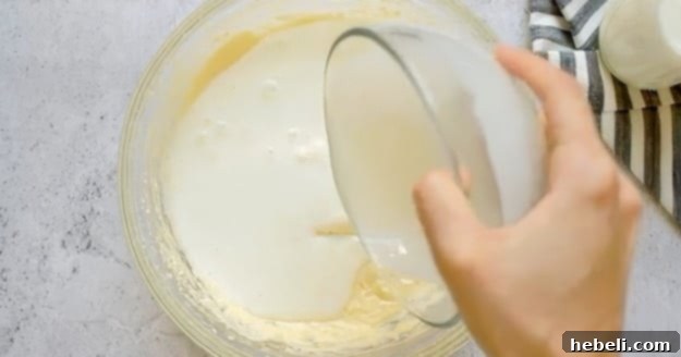 Pouring buttermilk into the cake batter mixture.