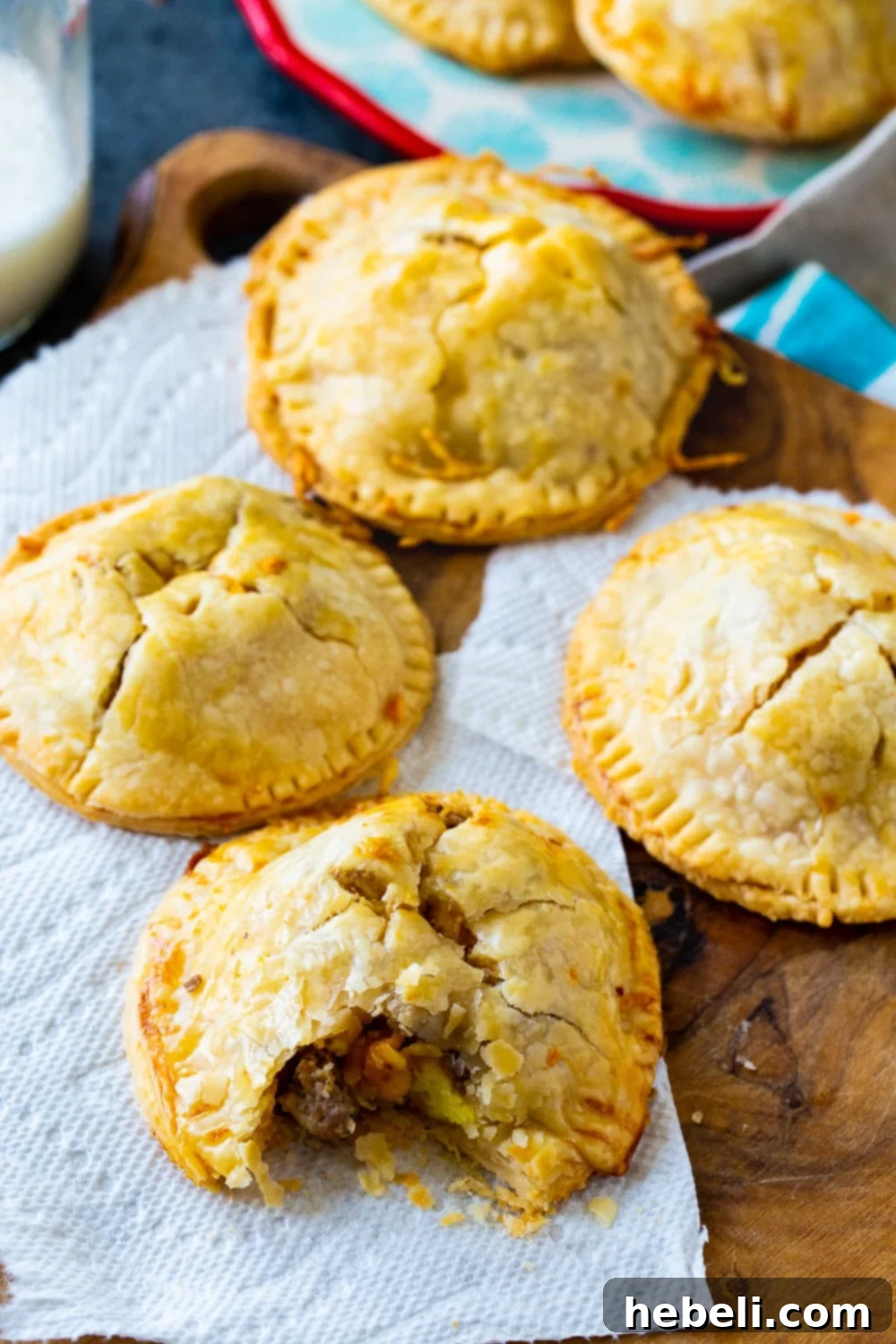 Overhead view of assembled Sausage, Egg, and Cheese Hand Pies on a baking sheet before baking.