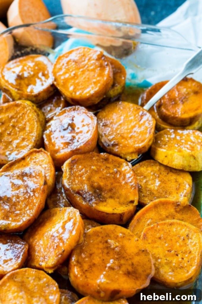 Classic Southern Candied Sweet Potatoes 3 Evenly sliced sweet potatoes arranged in a 9x13-inch baking dish before being covered with the butter and sugar glaze.