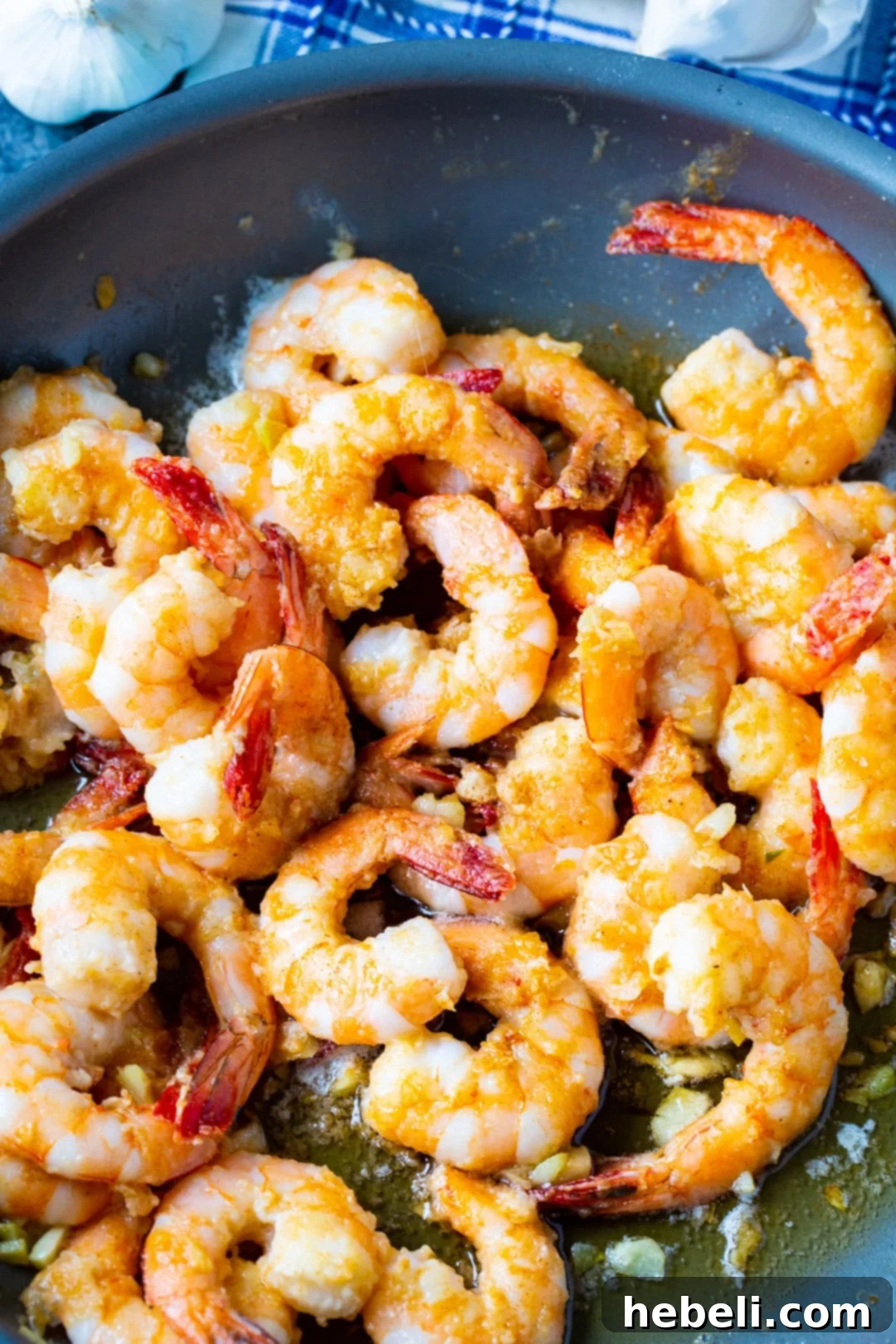 Aloha Garlic Shrimp 3 Close-up of garlic shrimp sizzling in a skillet, showcasing the golden color and texture.