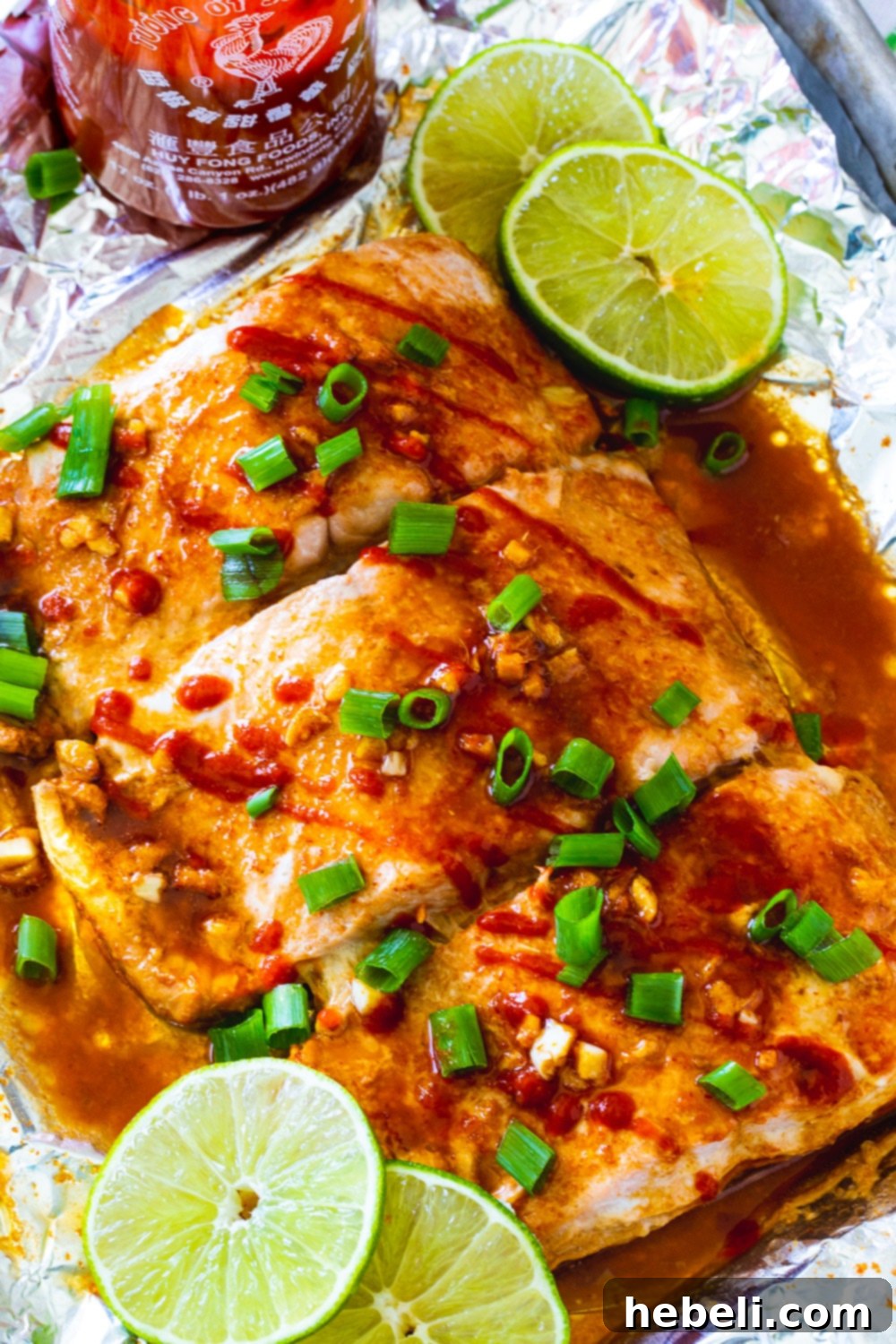 Overhead view of Firecracker Baked Salmon garnished with fresh green onions and lime, ready to be served.