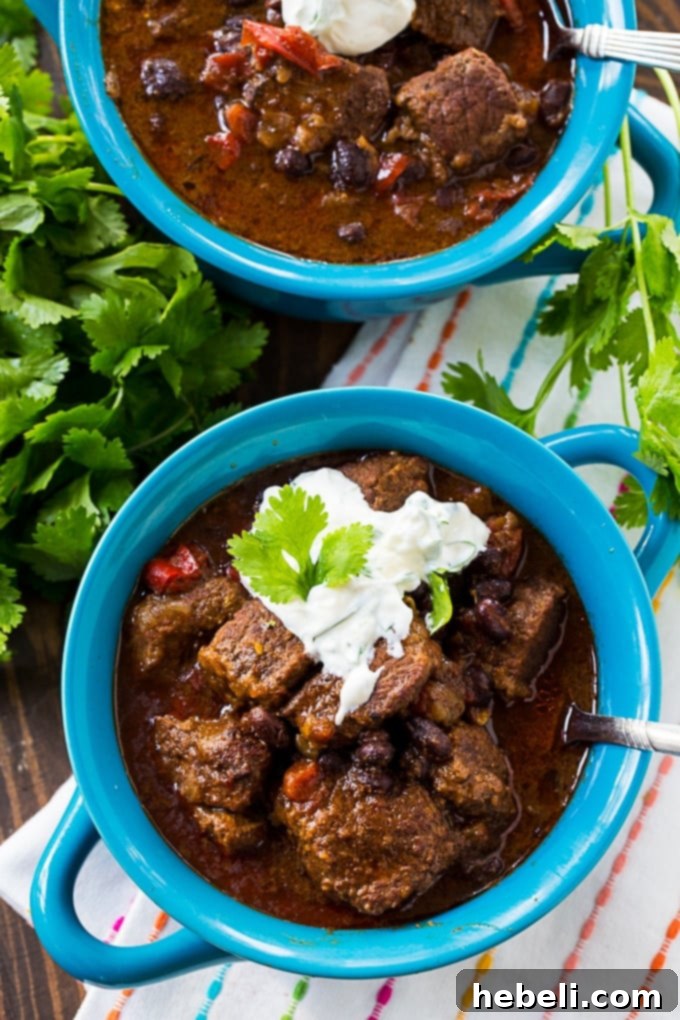 Slow Cooker Brisket Chili: A hearty bowl of chili with tender brisket, black beans, and fire-roasted tomatoes, topped with lime sour cream and fresh cilantro.