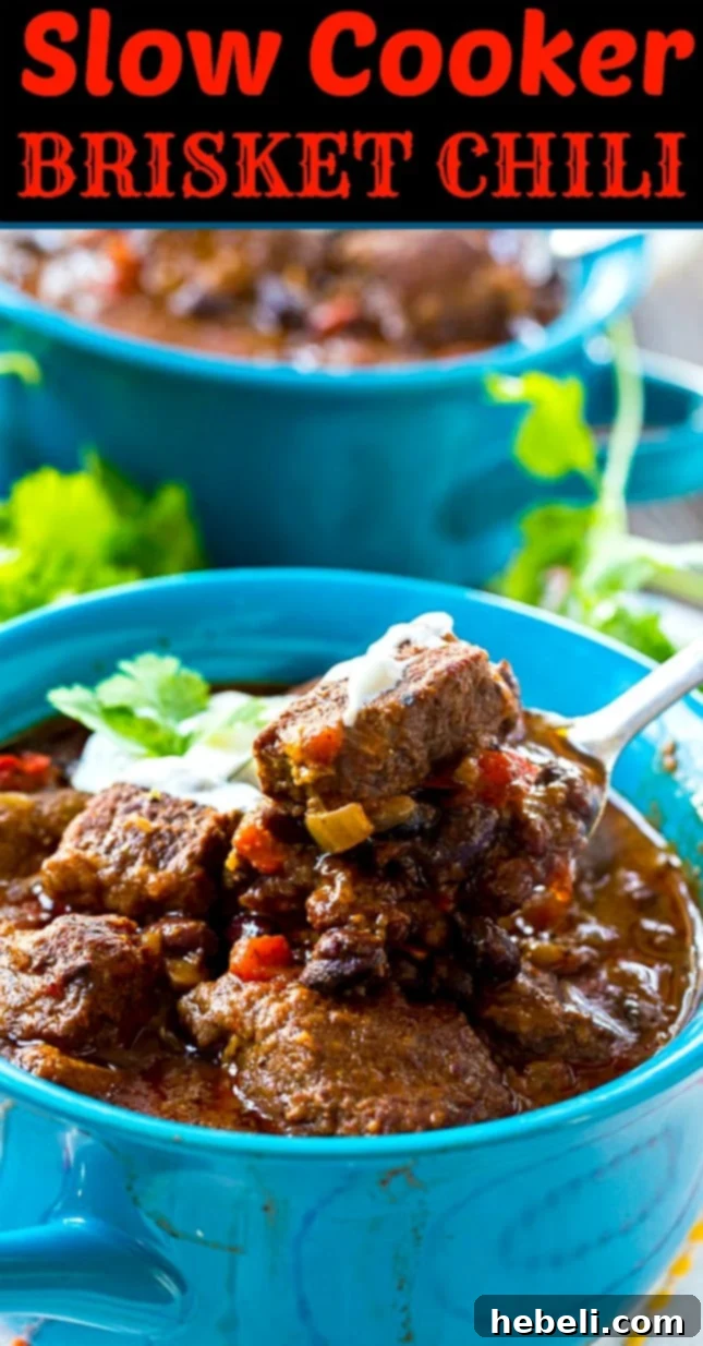 Large pot of Slow Cooker Brisket Chili, ready to be served, showcasing its rich texture and color.