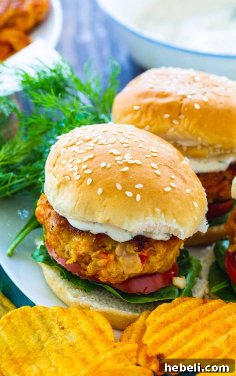 A close-up view of two cooked Crawfish Burgers on a white plate, showcasing their inviting texture.