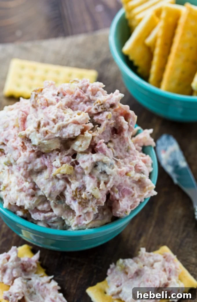 Southern Style Ham Relish 3 Close-up of Country Ham Relish with a spoon, showing its creamy texture and bits of ham.