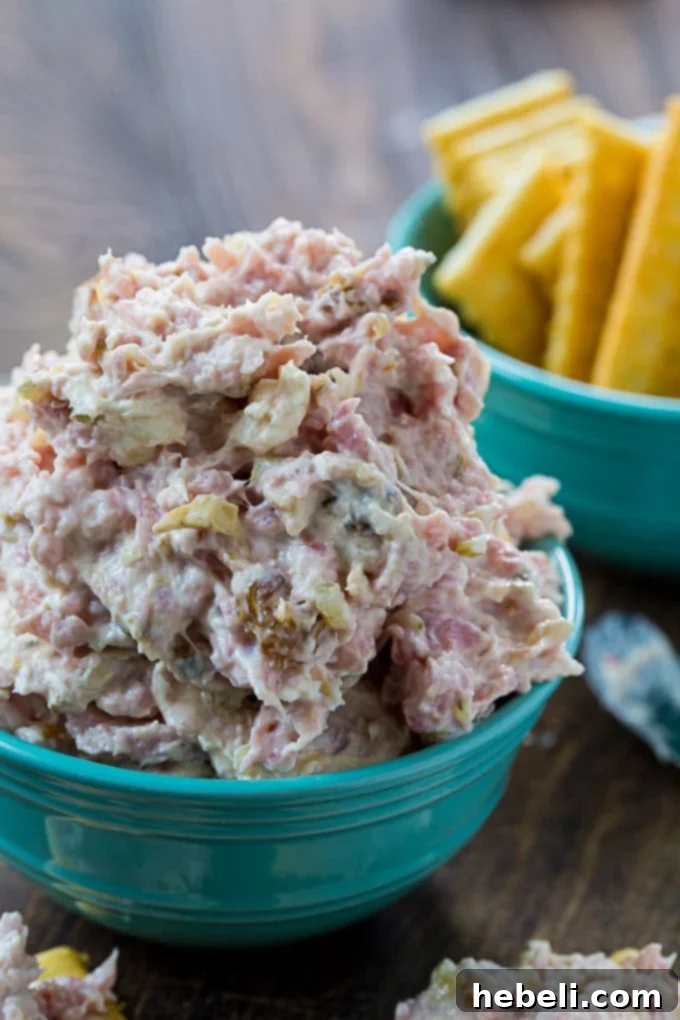 Southern Style Ham Relish 4 A bowl of Country Ham Relish with serving spoons, surrounded by crackers and fresh ingredients.