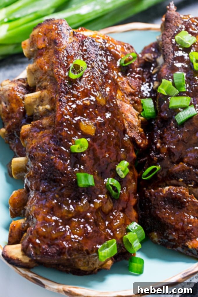 Close-up of a rack of Crock Pot Hawaiian Ribs simmering in a savory pineapple sauce, absorbing rich flavors.