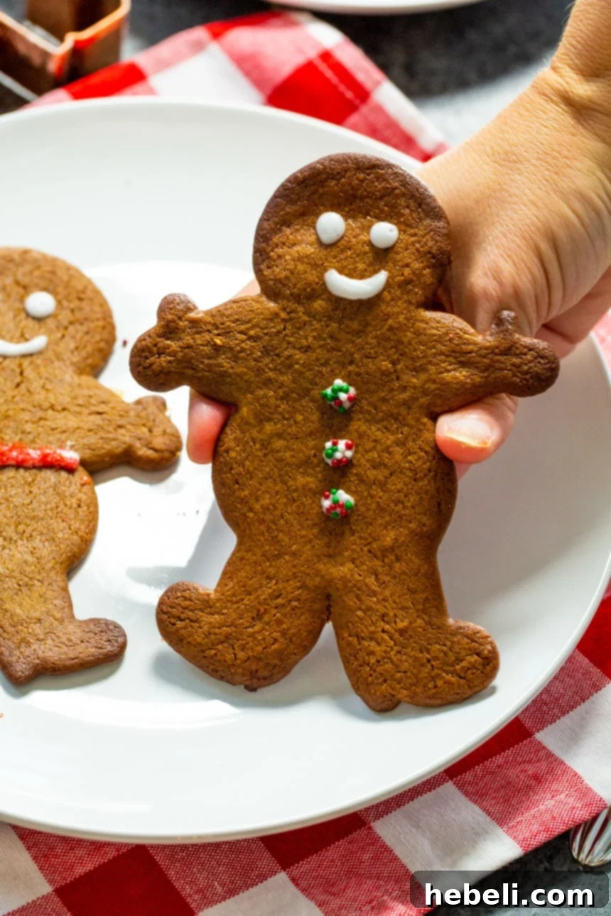Festive Gingerbread Delights 4 A hand gently holding a beautifully decorated gingerbread cookie, highlighting its festive appeal.