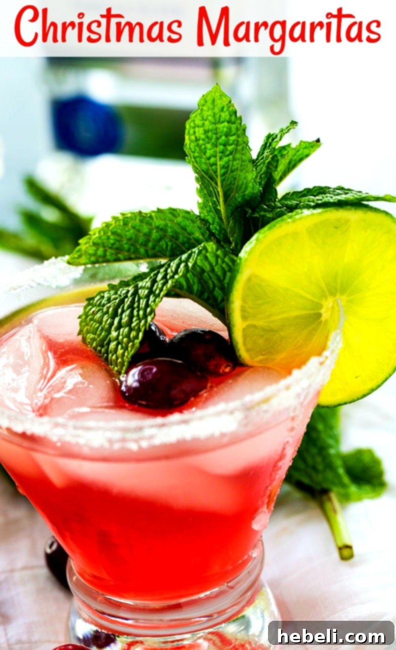 Jingle Juice Margaritas 4 A close-up of a beautifully garnished Christmas Margarita with fresh cranberries and mint, ready to be enjoyed.