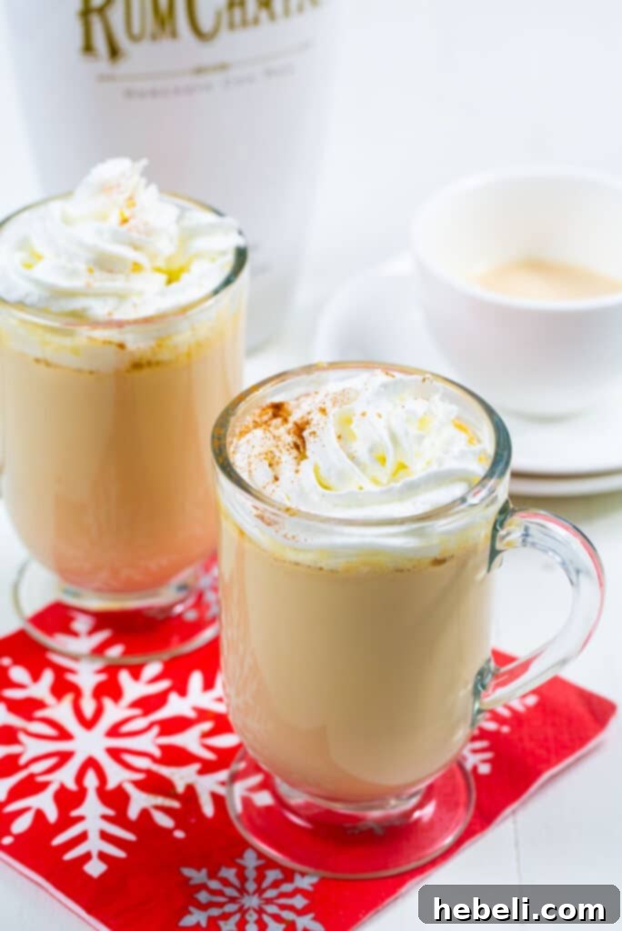 Decadent Slow Cooker Rumchata White Hot Cocoa 3 Rumchata White Hot Chocolate in two glasses topped with generous dollops of whipped cream.