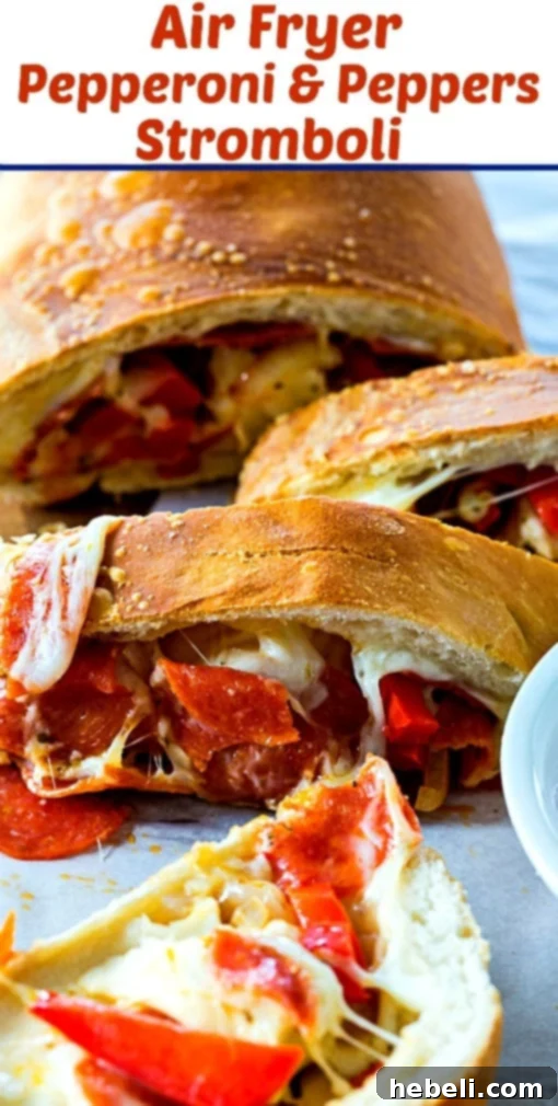 Easy Air Fryer Pepperoni and Peppers Stromboli 6 Two halves of an Air Fryer Pepperoni and Peppers Stromboli, revealing the gooey cheese and toppings