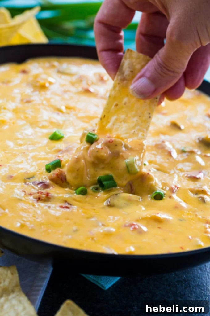 Close-up of Crawfish Queso with a spoon scooping